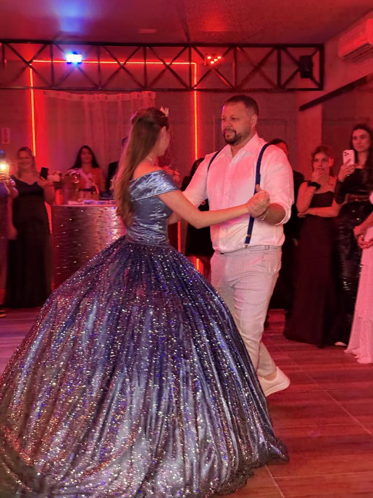 Valsa de 15 anos no salão de festas, com convidados ao redor