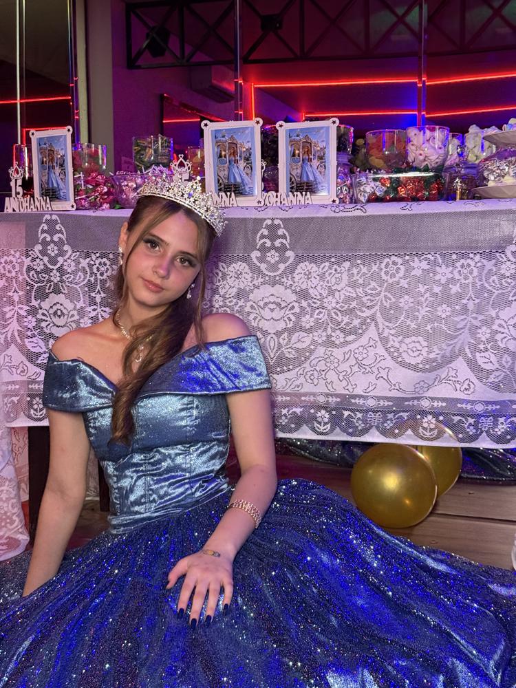 Debutante sentada em frente à mesa decorada