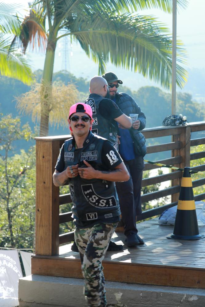 Convidados no deck mirante com palmeiras e montanhas ao fundo