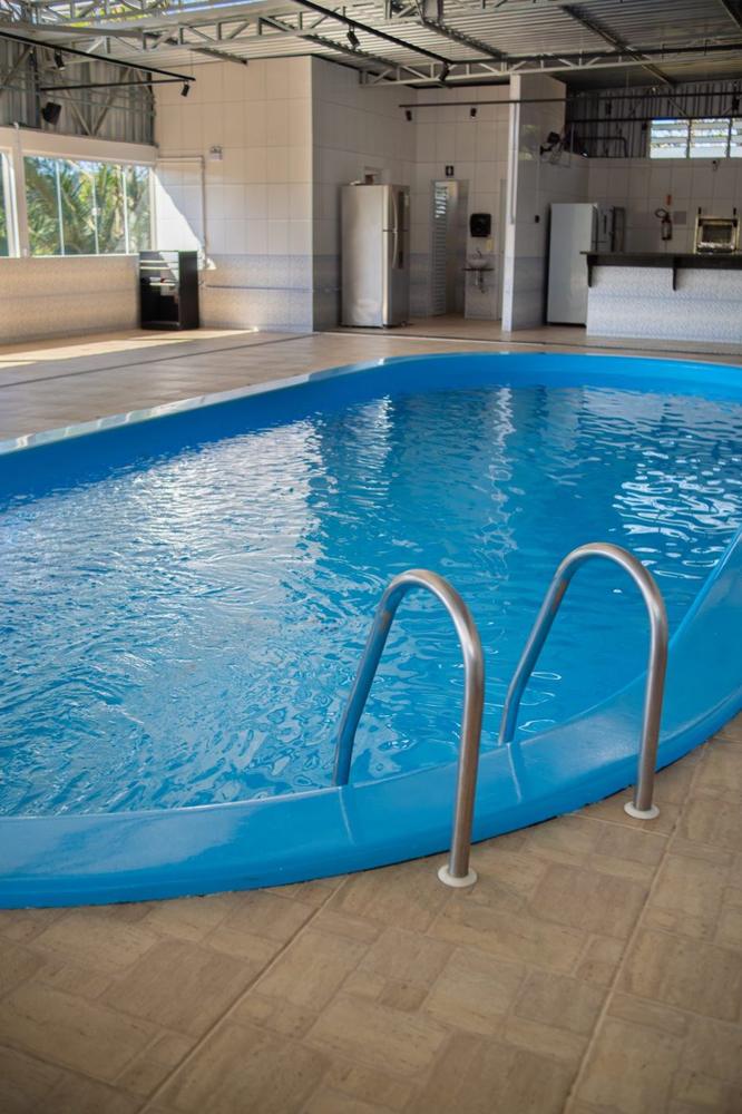 Piscina do Espaço Piscina, com escada de inox e cozinha ao fundo